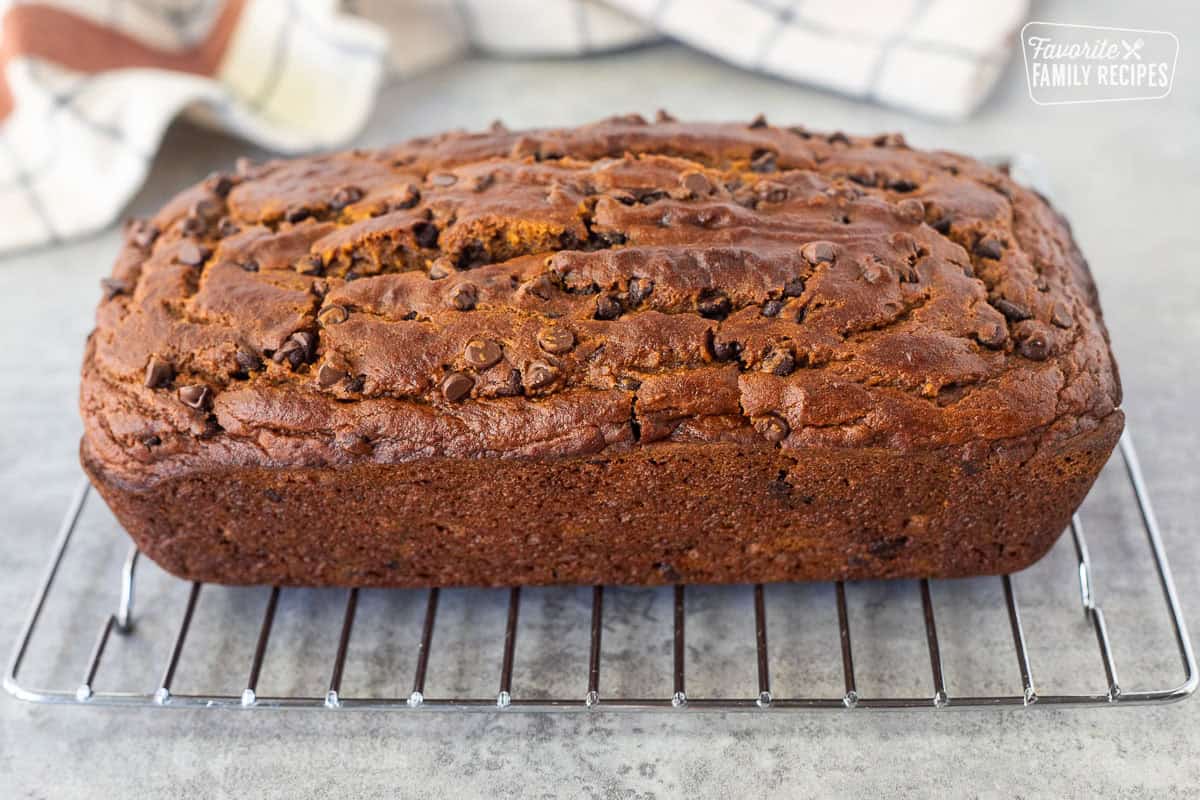Pumpkin chocolate chip bread loaf cooling on a wire rack.
