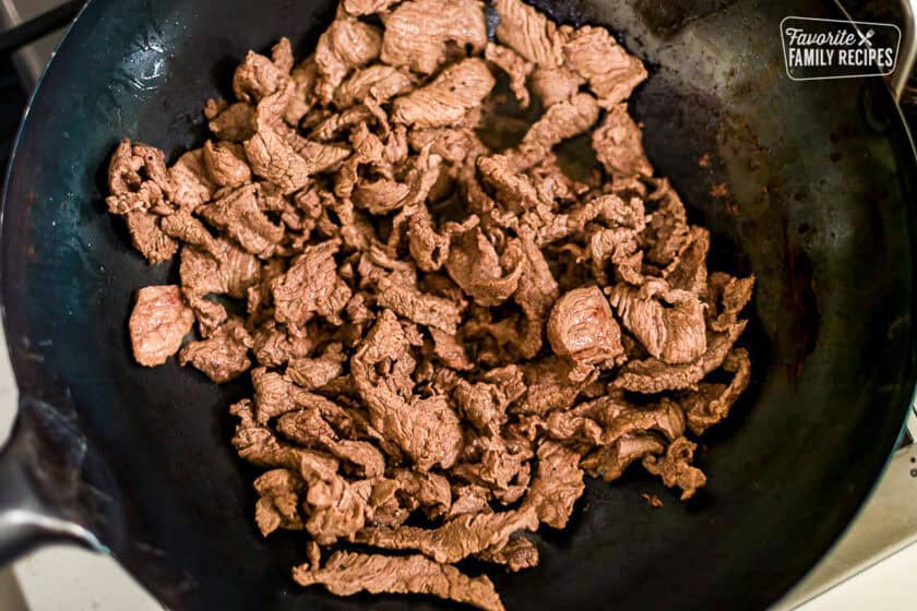 Cooking beef in a wok for beef and snow peas.