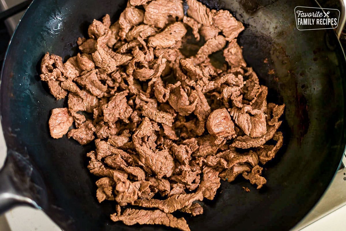 Cooking beef in a wok for beef and snow peas.