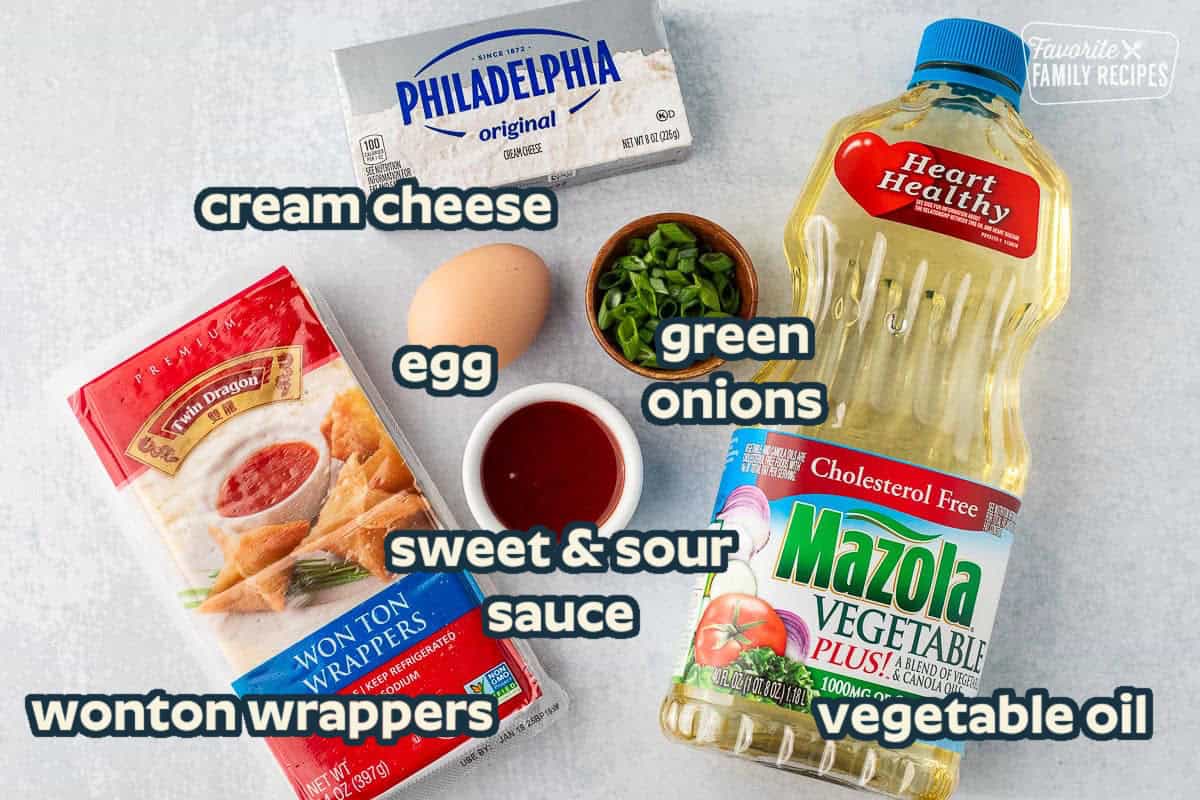 Ingredients to make cream cheese wontons including vegetable oil, cream cheese, green onion, egg, wonton wrappers and sweet-and-sour sauce.