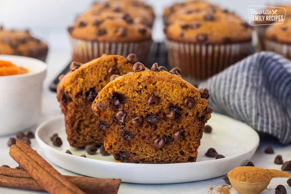 Pumpkin chocolate chip muffin cut in half on a plate.