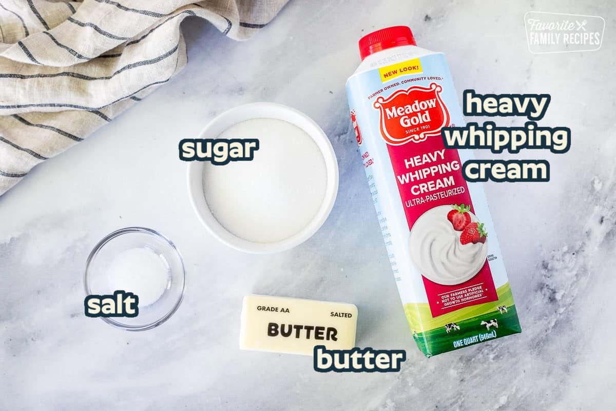 Ingredients to make Salted Caramel Sauce including heavy whipping cream, sugar, butter and salt.