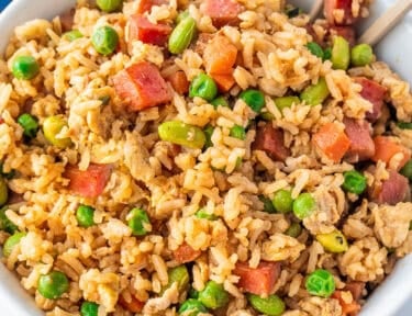 Bowl of spam fried rice with spam, carrots, peas, soy beans and scrambled eggs.