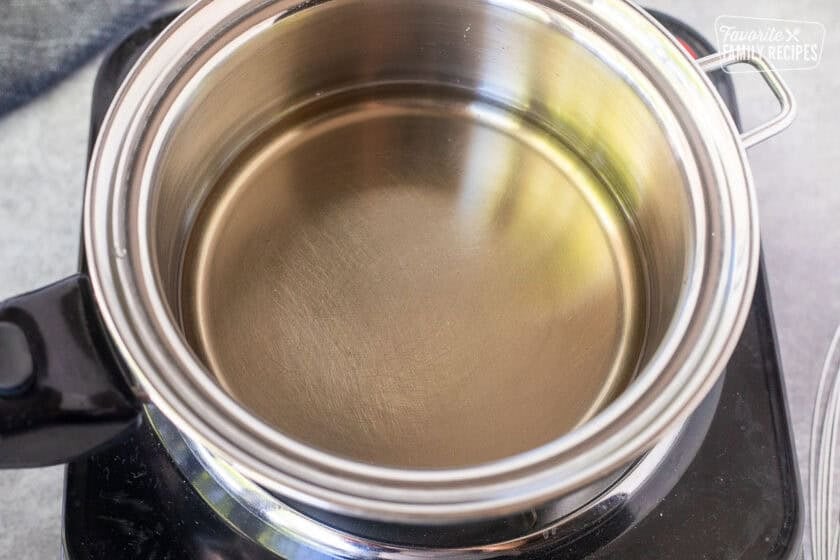 Saucepan with rice vinegar mixture over an electric burner.