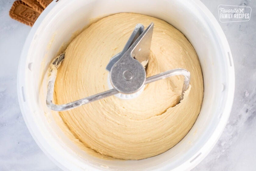Cinnamon roll dough in a mixing bowl with a dough hook attachment.