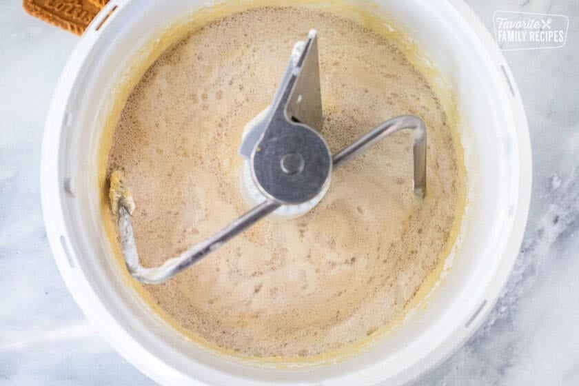 Adding yeast to mixing bowl with dough hook.