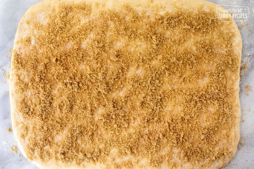 Rolled out dough with butter, sugars and cinnamon.