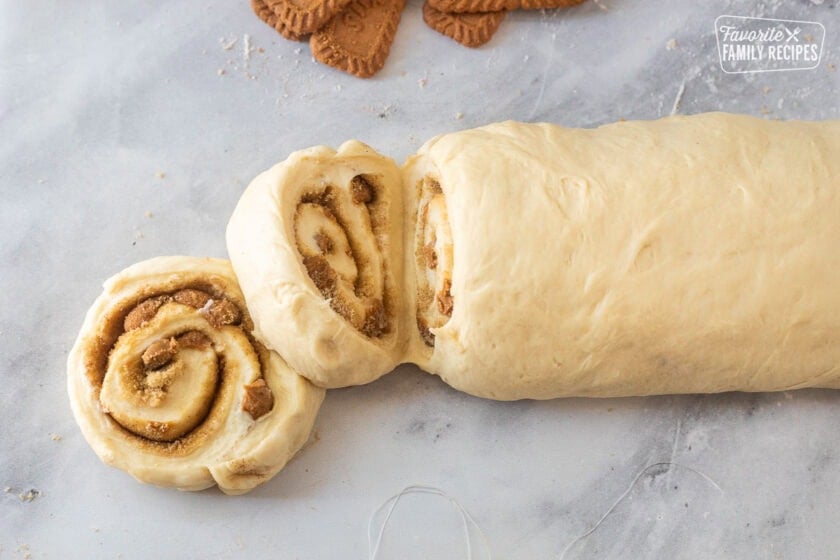 Cutting one inch Biscoff cinnamon rolls with floss.