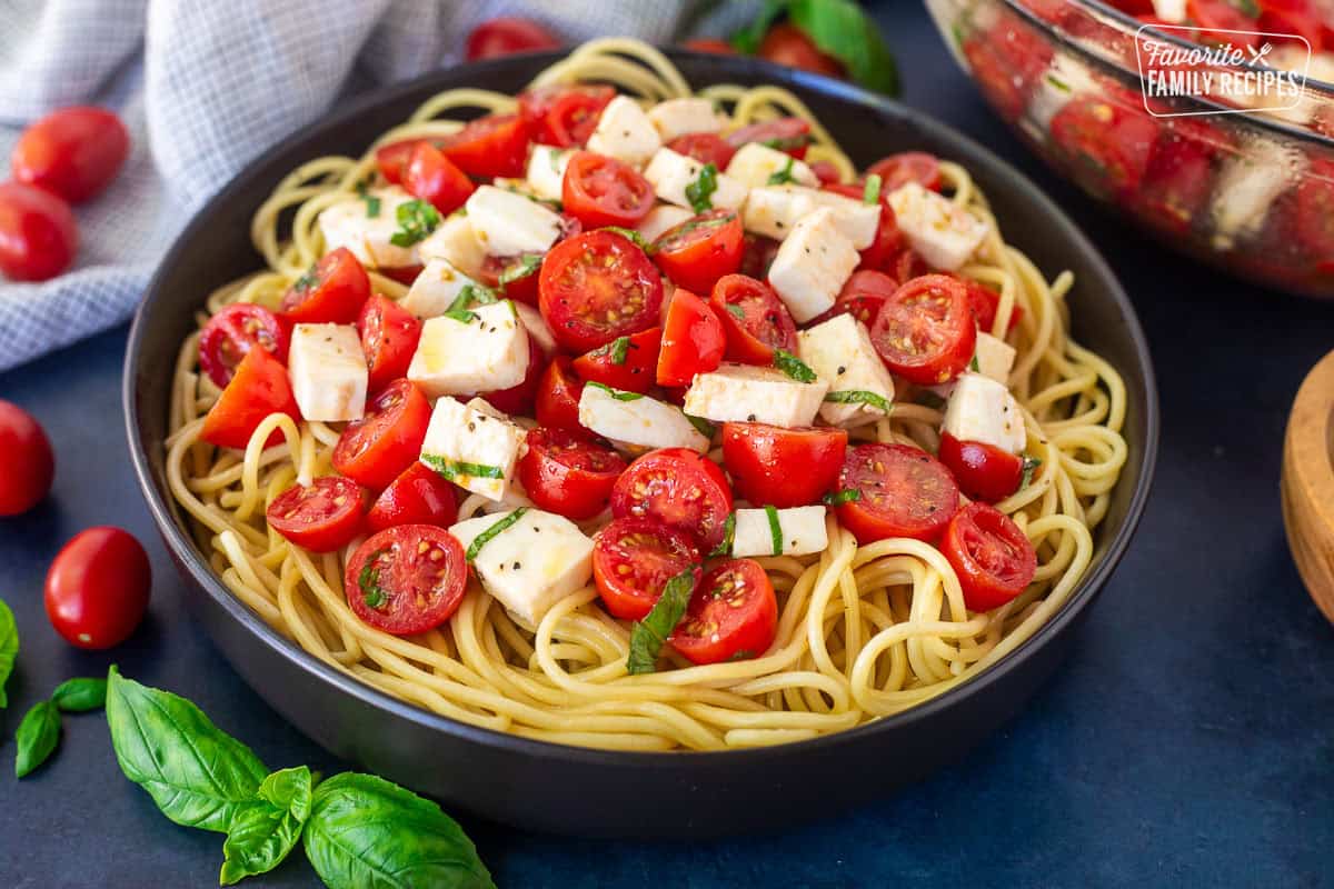 Tomato Basil Pasta with spaghetti noodles, cherry tomatoes, mozzarella cheese and fresh basil in an olive oil vinegar dressing.
