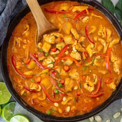 Chicken Panang curry with red bell peppers, peas, potatoes, tomatoes, peas and carrots.