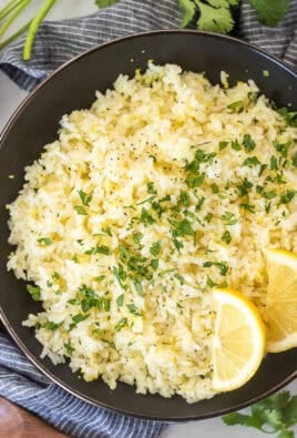 Easy lemon rice in a bowl and garnished with cilantro and fresh lemon wedges.