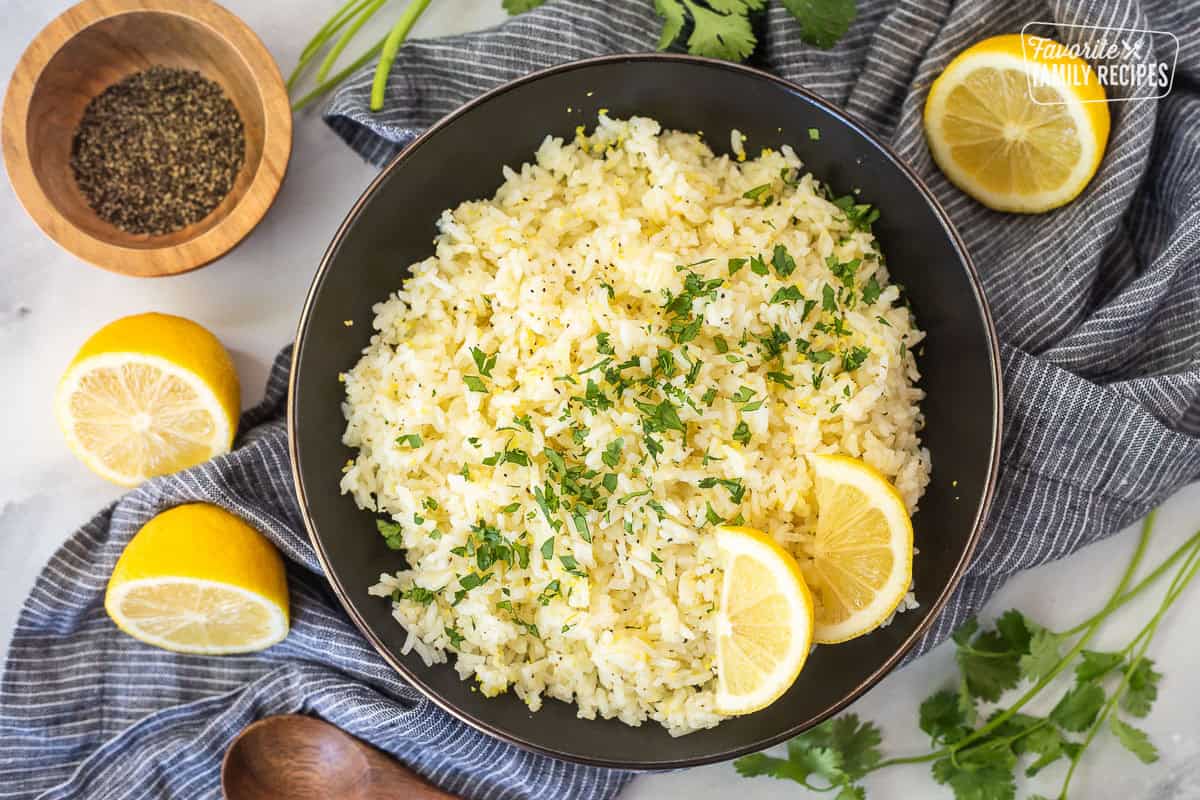 Easy lemon rice in a bowl and garnished with cilantro and fresh lemon wedges.