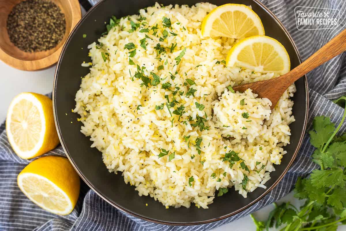 Bowl of easy lemon rice with lemon wedges and cilantro.