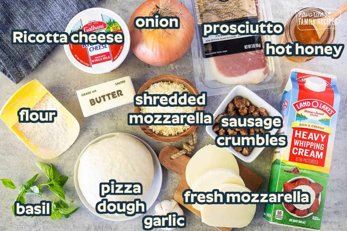 Ingredients to make hot honey pizza including hot honey, heavy whipping cream, prosciutto, sausage, mozzarella cheese, pizza dough, garlic, onion, ricotta cheese, butter, flour and fresh basil.