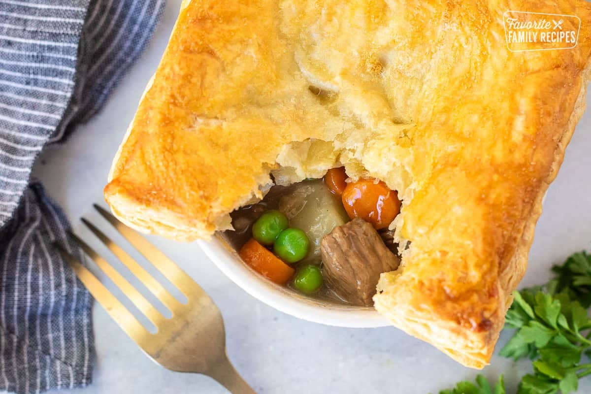 Instant Pot Beef Pot Pie in a ramekin with beef, carrots, potatoes, peas and gravy.