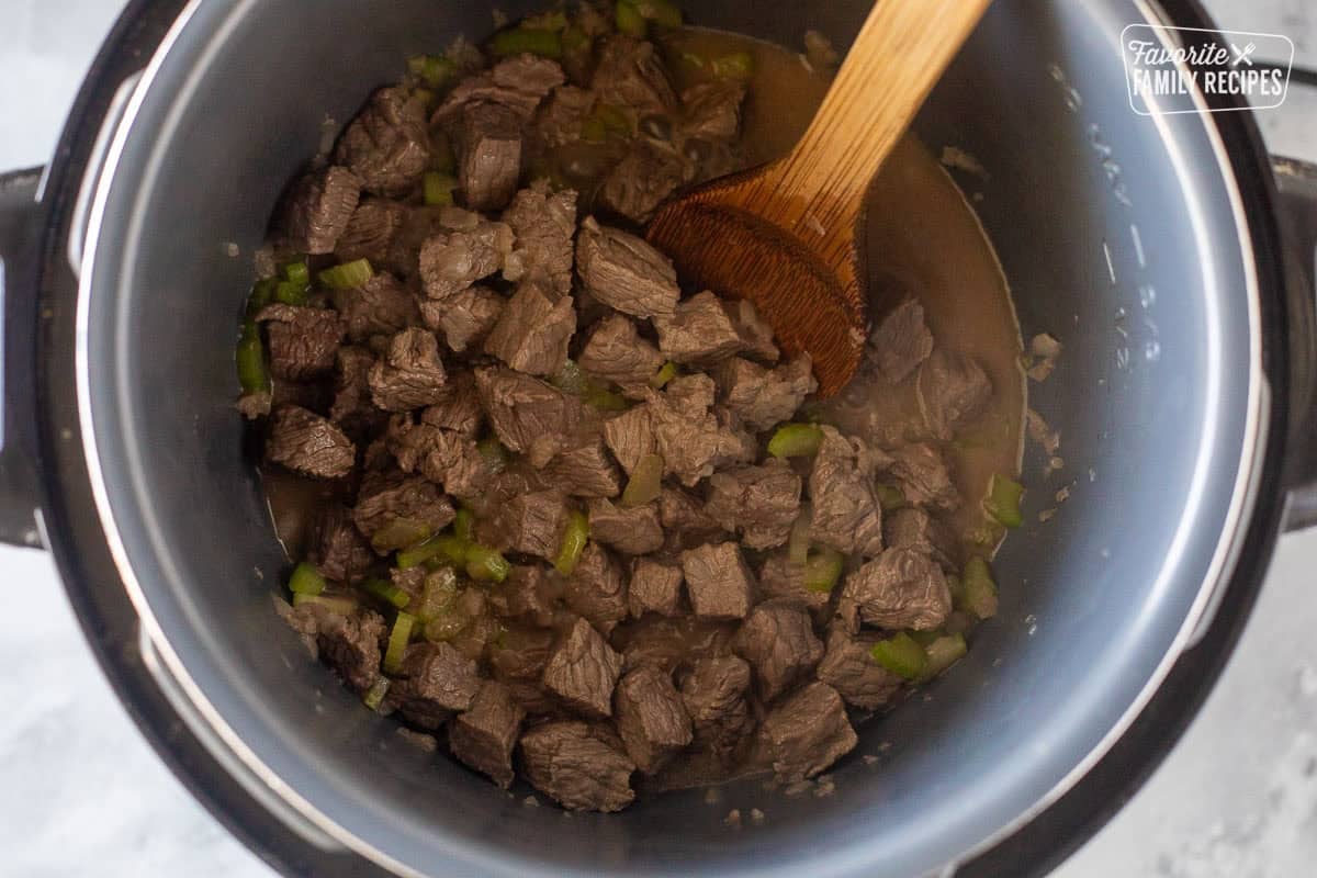 Instant pot with cooked beef and celery and onion.