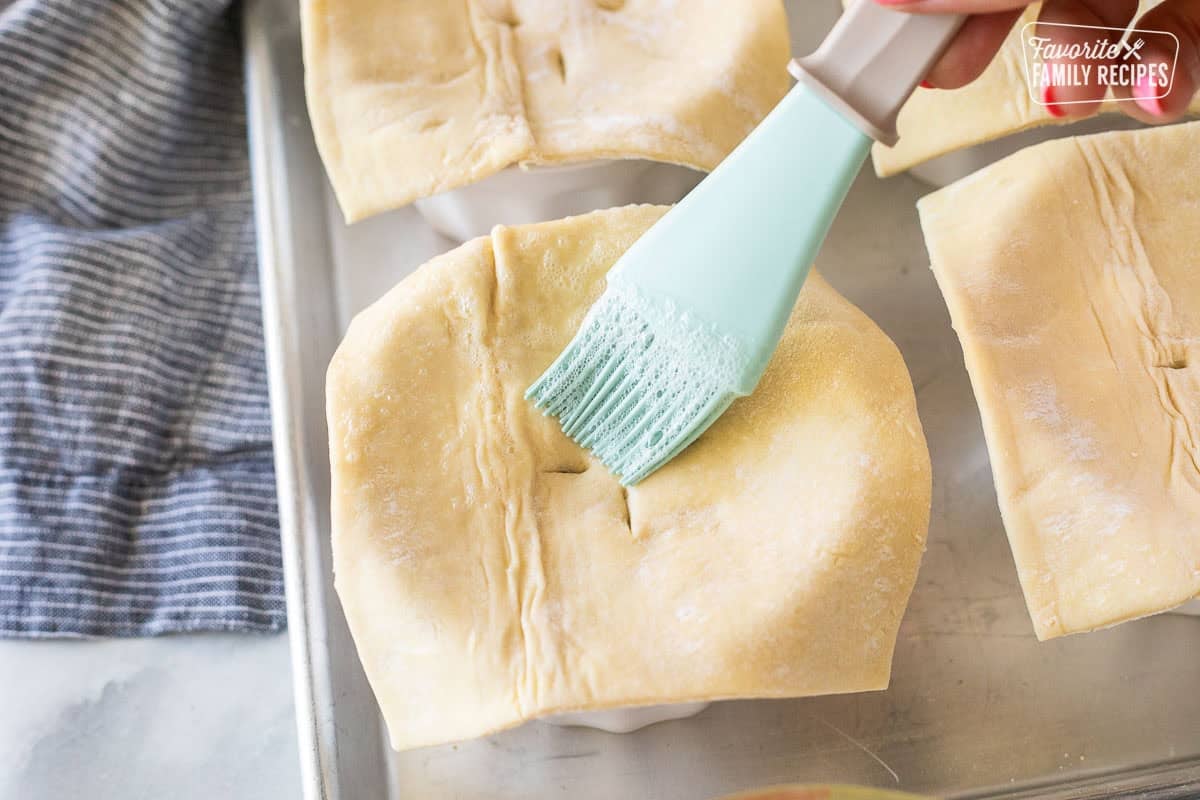 Brushing puff pastry with egg wash.