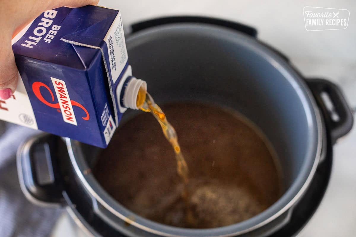 Pouring beef broth into instant pot.