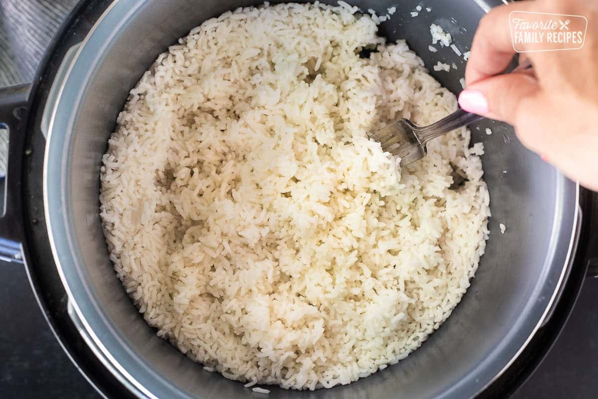 Fluffing rice in an instant pot with a fork.