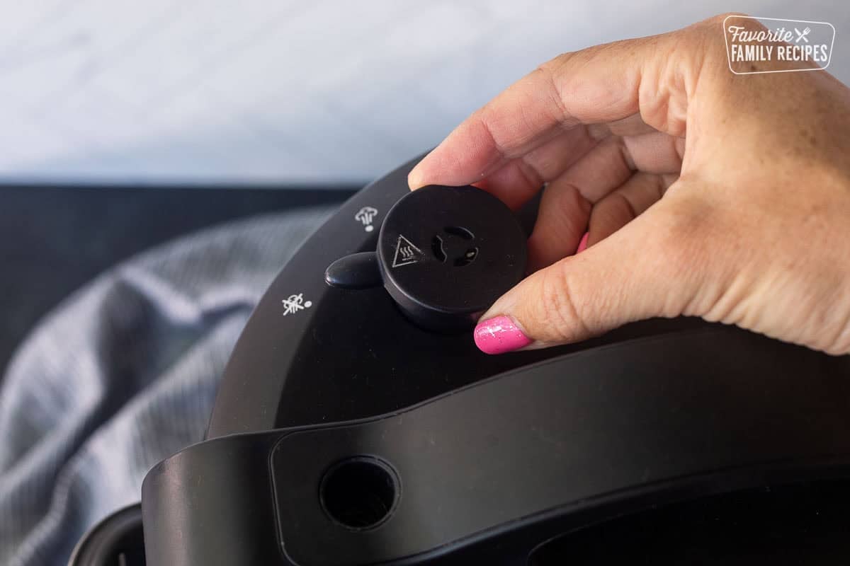 Hand turning instant pot to sealed pressure mode.