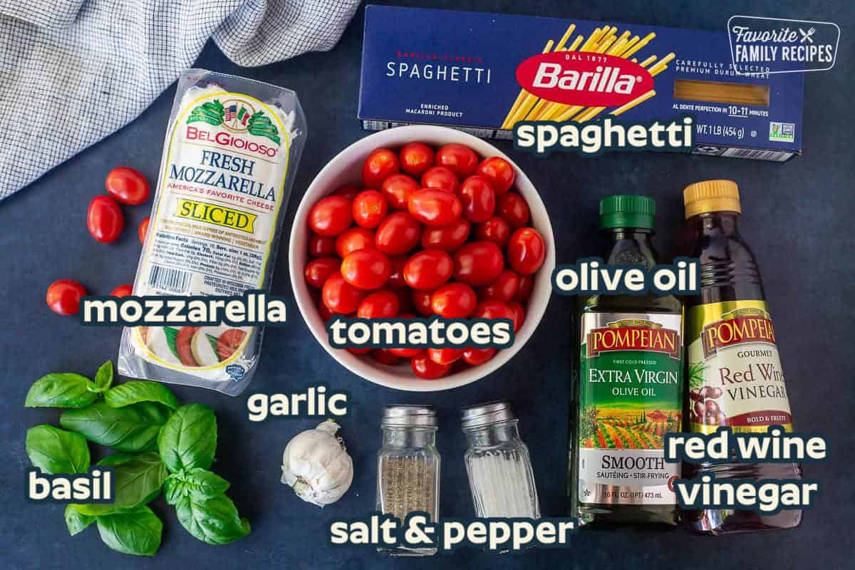 Ingredients to make Tomato Basil Pasta including cherry tomatoes, fresh mozzarella, basil, olive oil, red wine vinegar, salt, pepper, garlic and spaghetti noodles.