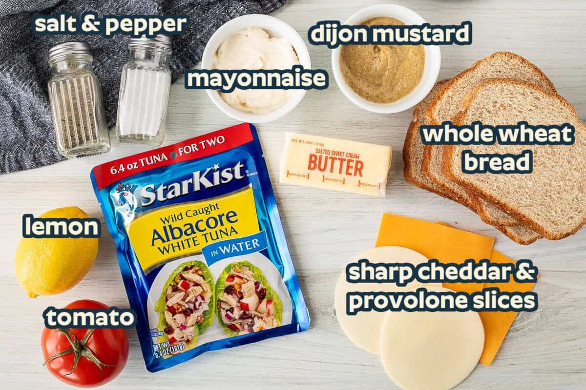 Ingredients needed to make a tuna melt sandwich: Albacore tuna, bread, mayonnaise, dijon mustard, cheese slices, lemon, tomato, butter, salt and pepper.