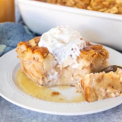 Cut corner of a slice of Apple Bread Pudding with caramel sauce and whipped cream.