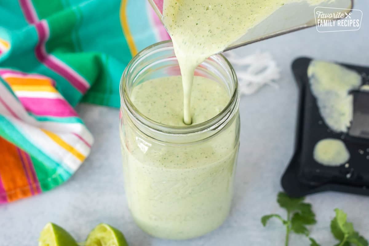 Pouring Cilantro Lime Sauce from blender into a glass mason jar.