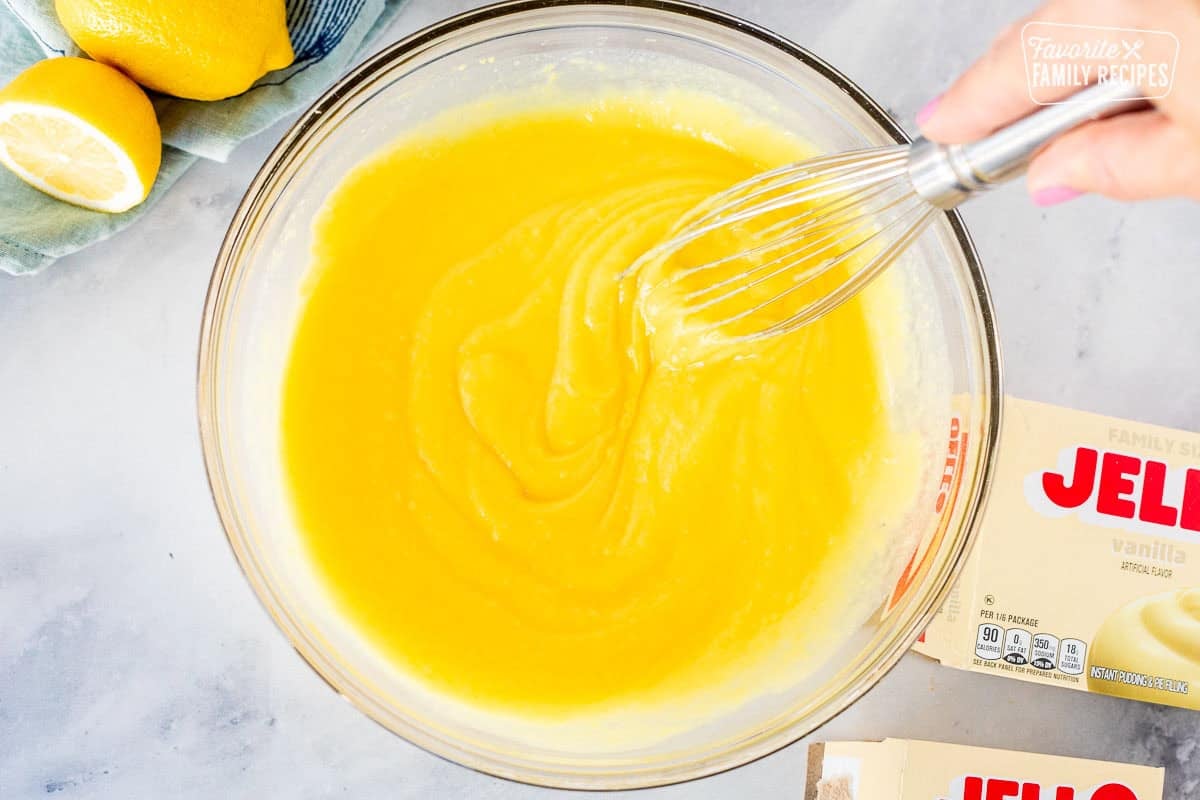 Whisking vanilla pudding mix in a large glass bowl.