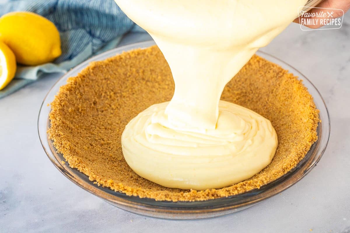 Pouring Lemon pie filling into graham cracker crust.