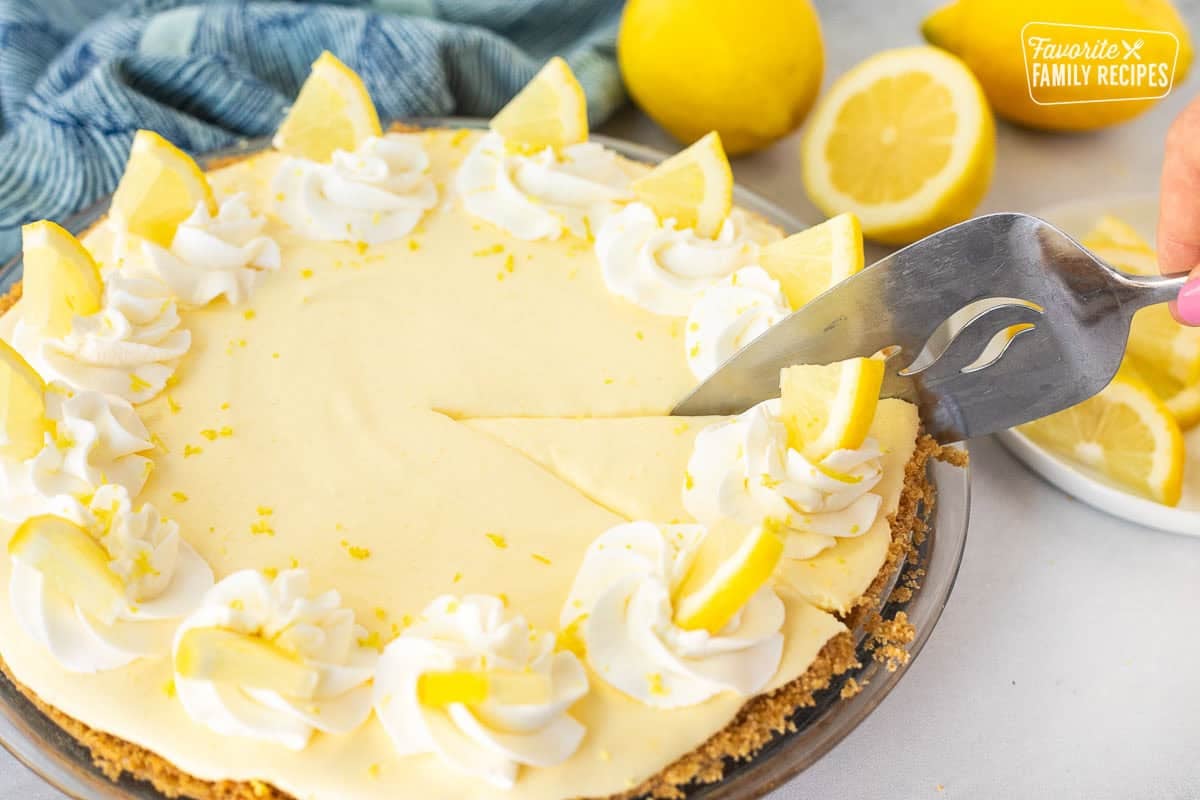 Slicing into a Creamy Lemon Pie with a pie server.