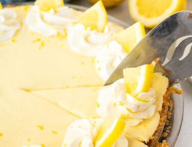 Slicing into a Creamy Lemon Pie with a pie server.
