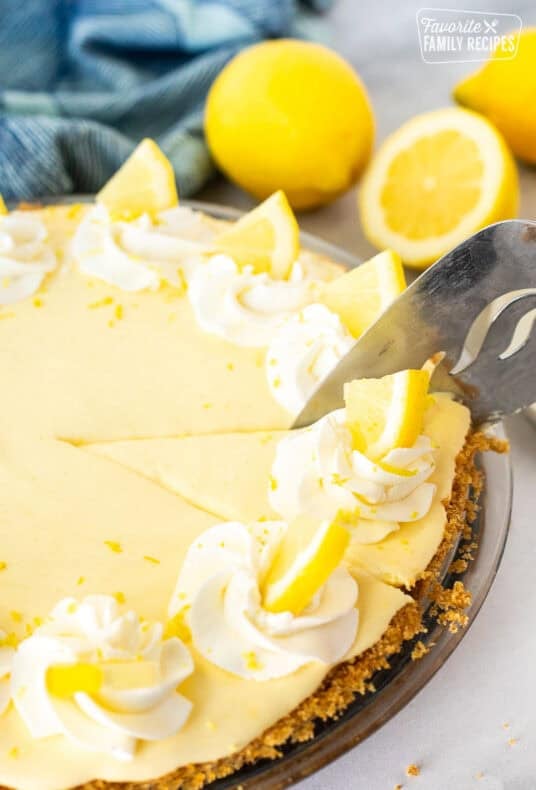 Slicing into a Creamy Lemon Pie with a pie server.