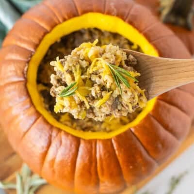 Wooden spoon with Dinner in a Pumpkin garnished with rosemary.
