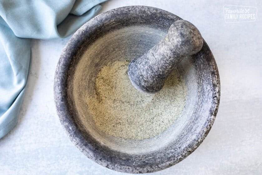 Ground seasonings in a stone mixing bowl for homemade ranch recipe.