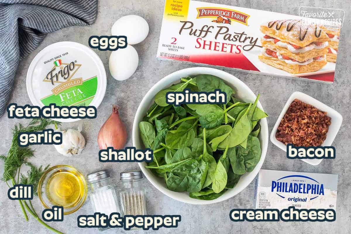 Ingredients to make Kronk's Spinach Puffs including spinach, bacon, puff pastry, cream cheese, eggs, feta cheese, scallions, salt, pepper, olive oil, dill and garlic.