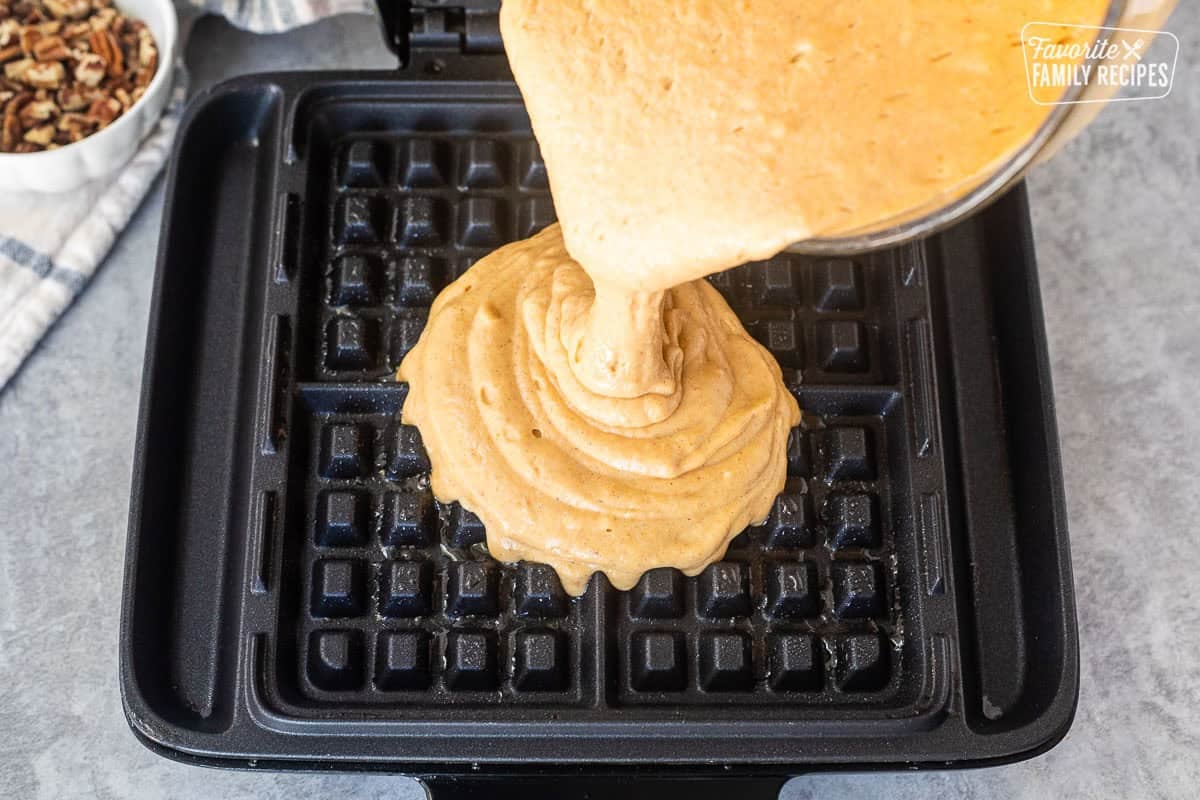 Pouring Pumpkin Waffle batter into a waffle iron.