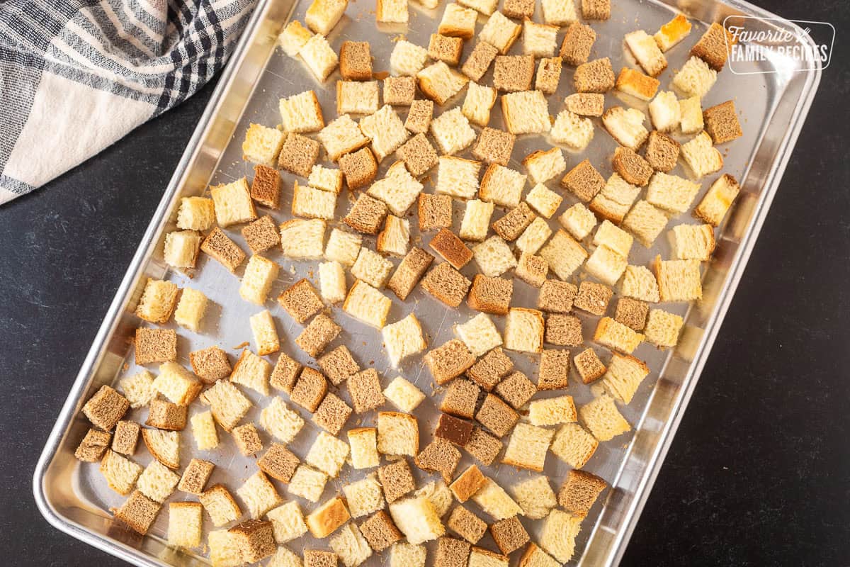 Sheet pan with toasted cubes of white and wheat bread.