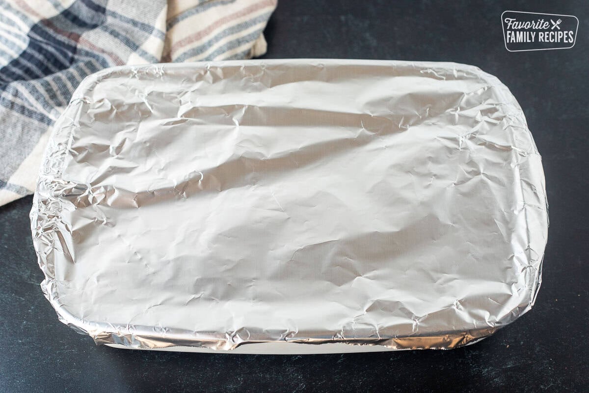 Aluminum foil on top of baking dish of sausage stuffing.