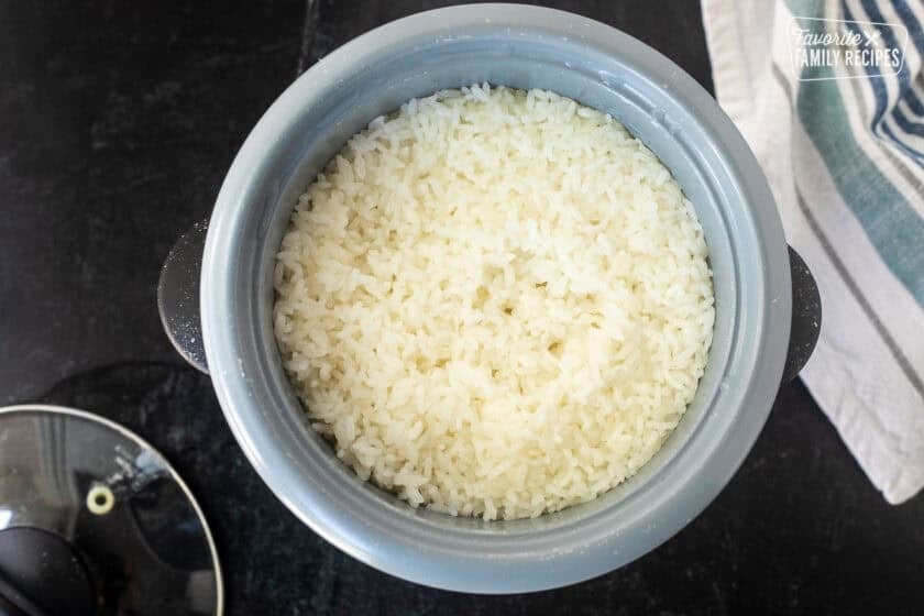 Rice cooker with cooked sushi rice.