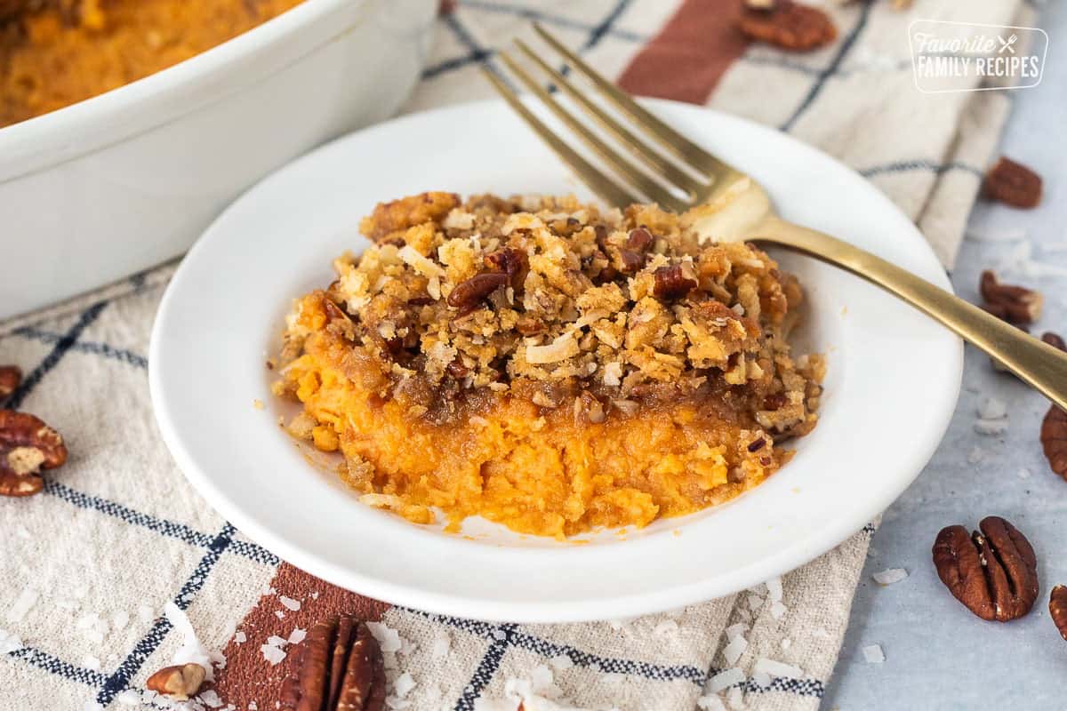Sweet Potato Casserole with Pecan Topping on a plate with a fork.