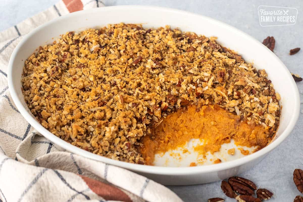 Sweet Potato Casserole with Pecan Topping in a baking dish with a portion missing.