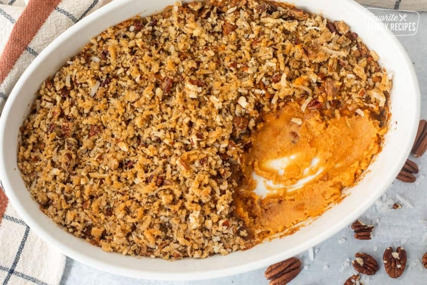 Sweet Potato Casserole with Pecan Topping in a baking dish with a portion missing.