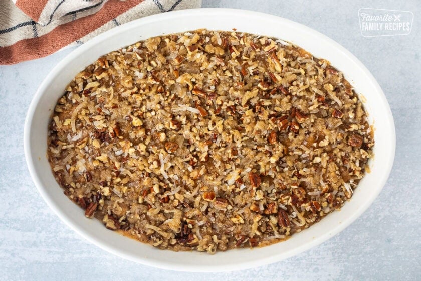 Unbaked sweet potato casserole with pecan topping in a baking dish.