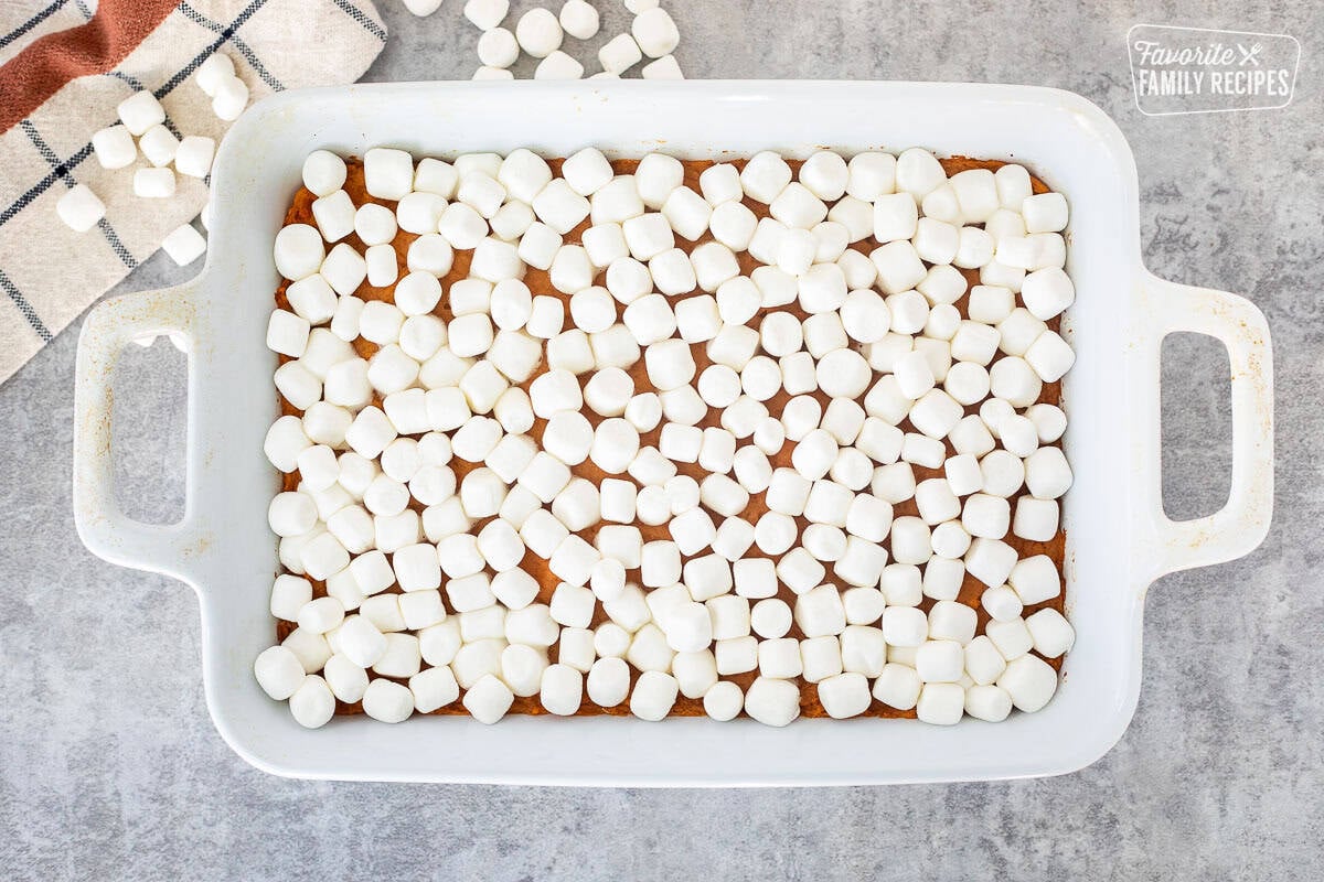 Marshmallows on top of sweet potatoes in a baking dish.