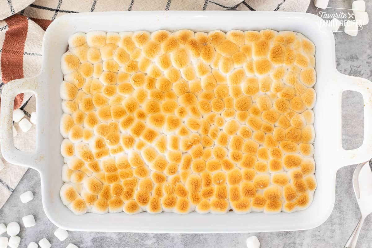Baked sweet potatoes in a baking dish with marshmallow golden tops.