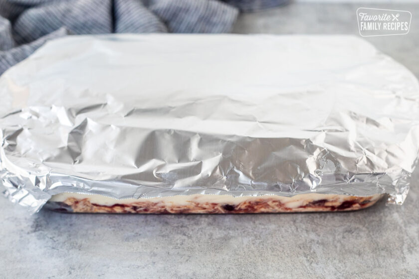 Aluminum foil on top of glass baking dish of Thanksgiving Leftover Casserole.