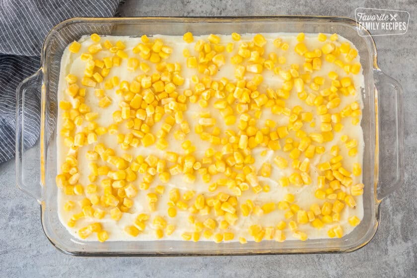 Glass baking dish with mashed potatoes and corn layer.