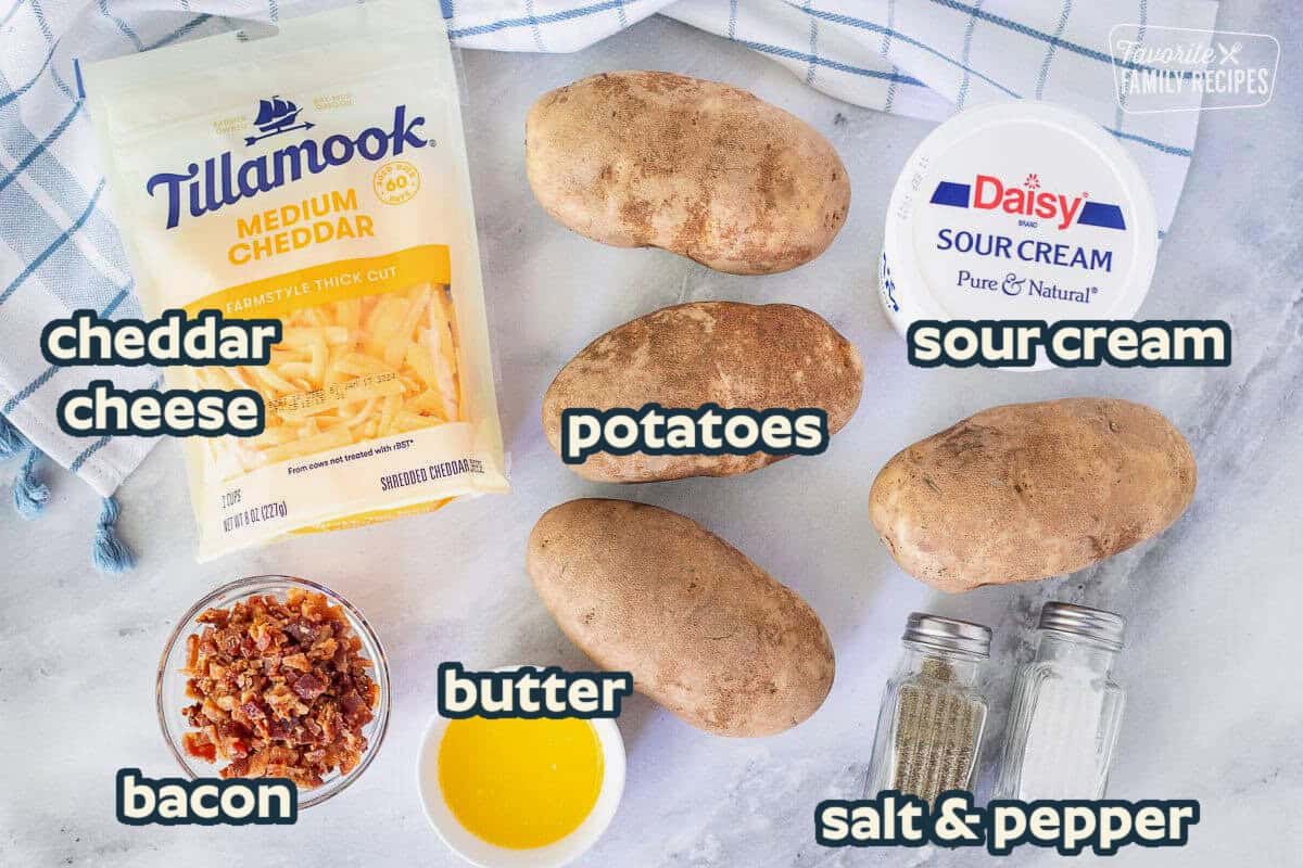 Ingredients to make Twice Baked Potatoes including potatoes, cheese, sour cream, bacon bits, butter, salt and pepper.