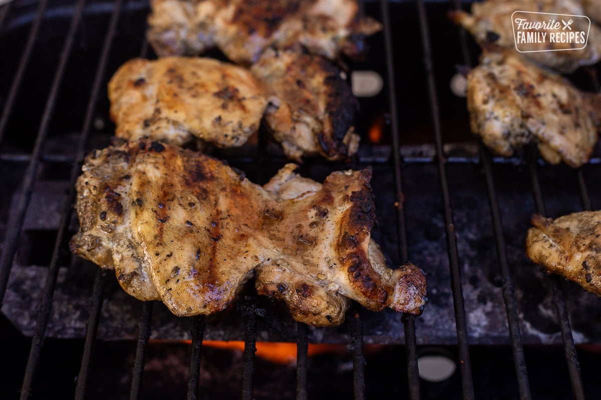 Marinaded chicken thighs on barbecue.